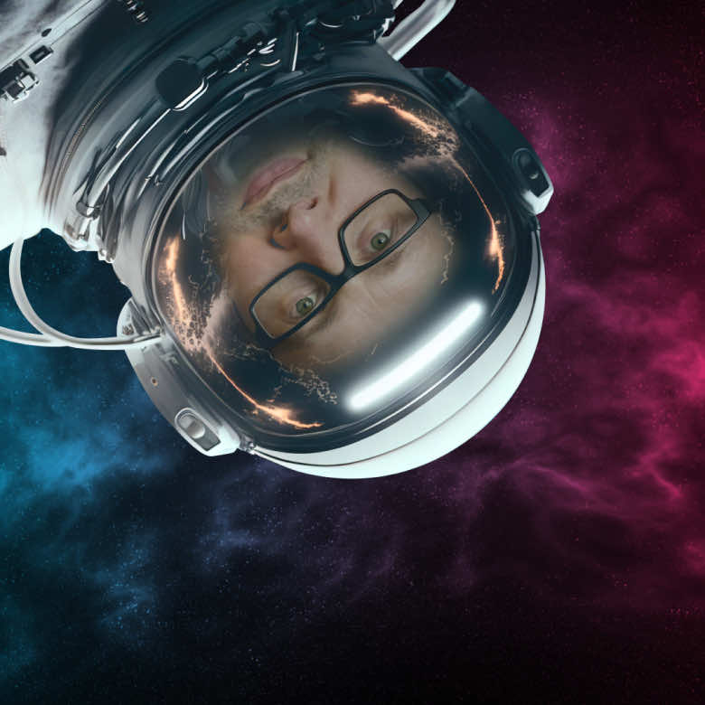 Rob Winter, wearing a spacesuit, floating upside down in the pink & blue cosmos!